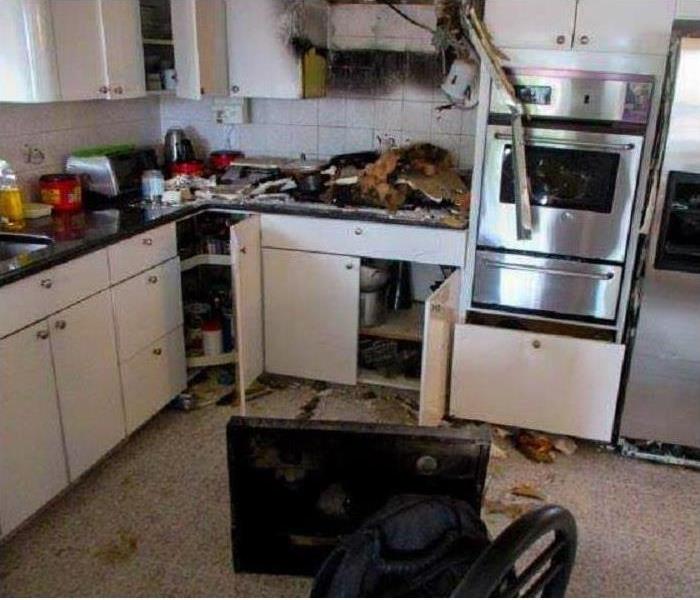 microwave and stovetop charred and on floor, burnt wall